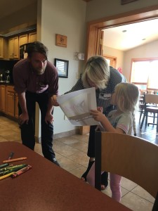Five-year-old Khloe shows Ann and Jim her billboard she colored with crayons.